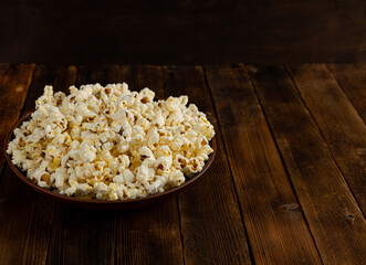 A bowl of delicious popcorn on a wooden table