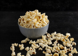 A bowl of delicious popcorn on a dark background