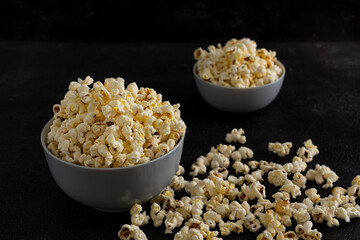 A bowl of delicious popcorn on a dark background