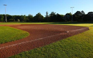 The first base on baseball field shot in the early morning.