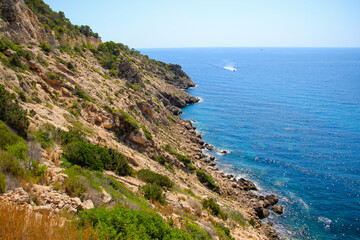 Fototapeta na wymiar Rocky hills next to the Mediterranean Sea in the cove of Cala Llonga in the southeast of Ibiza in the Balearic Islands, Spain