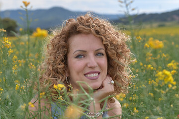 Young girl in the field, looking at the camera with smile.