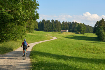 pretty senior woman riding her electric mountain bike in the Allgaeu mountains above Oberstaufen , Allgau Alps, Bavaria Germany
