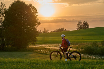 active woman riding her electric mountain bike at sunset in the Bregenz Forest mountains near Sulzberg, Vorarlberg, Austria

