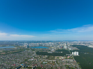 Big city in the distance: high-rise multi-storey modern houses, drone aerial shot. City Downtown in the distance: developed infrastructure against background of small suburban houses. Kyiv Panorama.
