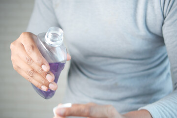 mouthwash liquid flowing into a cap close up 