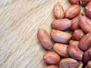Macro image of roasted peanuts on a wooden background. A place for text, copy space.