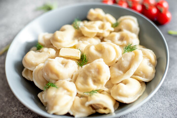 Homemade dumplings with meat - Russian dumplings. Dumplings with meat filling, ravioli on a stone background
