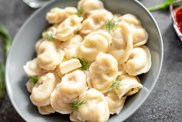 Homemade dumplings with meat - Russian dumplings. Dumplings with meat filling, ravioli on a stone background