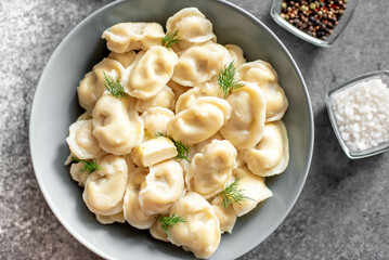 Homemade dumplings with meat - Russian dumplings. Dumplings with meat filling, ravioli on a stone background