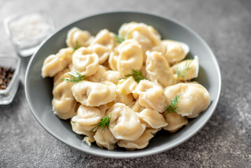 Homemade dumplings with meat - Russian dumplings. Dumplings with meat filling, ravioli on a stone background