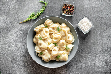 Homemade dumplings with meat - Russian dumplings. Dumplings with meat filling, ravioli on a stone background