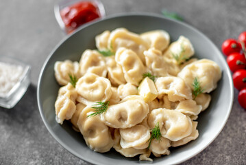 Homemade dumplings with meat - Russian dumplings. Dumplings with meat filling, ravioli on a stone background