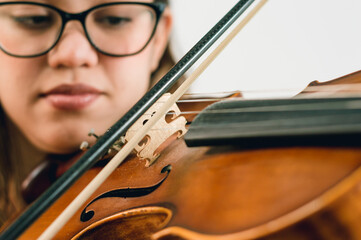 close up latin caucasian woman playing violin, focus on the strings