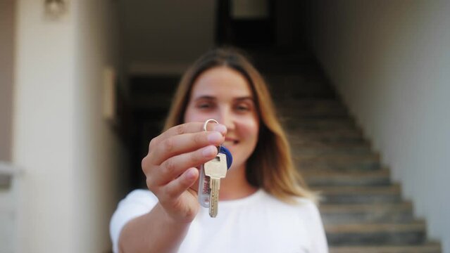 Portrait of happy homeowner person holding keys. Realtor real estate agent selling property, make special offer of affordable dwelling.