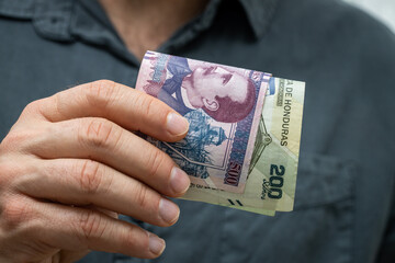 Honduras money, File of lempira banknotes held in an outstretched hand, business and financial...