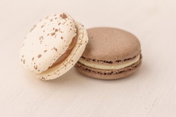 White macaroon and brown macaroon on white background. Salted caramel macaroon, chocolate macaroon. Traditional french dessert for coffee