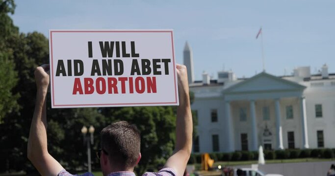 WASHINGTON, DC - Circa 2022 - A man holds an anti-abortion protest sign outside the White House.	