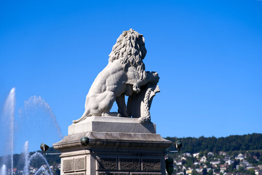 Stone lion sculpture at Enge port at City of Zürich with sailing boats on a sunny summer day. Photo taken June 11th, 2022, Zurich, Switzerland.