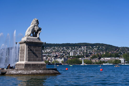 Stone lion sculpture at Enge port at City of Zürich with sailing boats on a sunny summer day. Photo taken June 11th, 2022, Zurich, Switzerland.