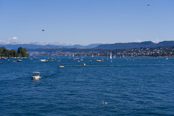Scenic landscape with Lake Zürich, leisure boats and Swiss Alps in the background on a sunny summer day seen from City of Zürich. Photo taken June 11th, 2022, Zurich, Switzerland.
