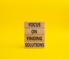 Focus on finding solutions symbol. Concept words Focus on finding solutions on wooden blocks. Beautiful yellow background. Business and Focus on finding solutions concept. Copy space