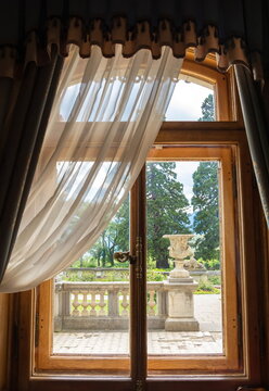 Window with beautiful curtains overlooking the terrace and the old park