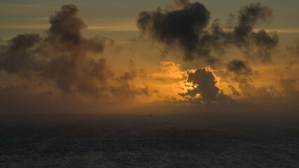 Sunset over the sea and boat near Neist Point Lighthouse  Isle of Skye Scotland