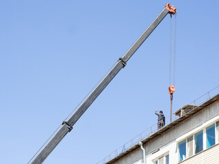 the builder works on the roof of the house, takes the load on the roof