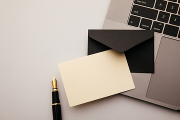 Envelope and laptop on white table background. Home office
