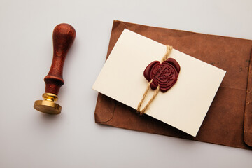 Paper envelope with red wax seal and stamp on a table, postal accessories