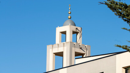 Top of a mosque, in a blue sky and trees