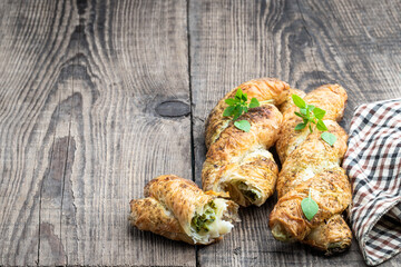 Puff pastry braid stuffed with minced meat on wooden table
