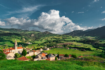 Fototapeta na wymiar Scenic alpine town in the green mountain valley.