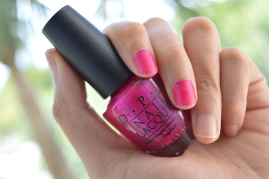 Hot Pink nail polish bottle held in hand in Fort Lauderdale, FL, USA on June 20, 2015