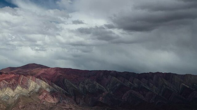 Time lapse of the Hornocal sierra in Jujuy, Argentina. View of the colorful rocky mountains and dramatic sky with fast moving clouds passing by, creating beautiful shadows and texture. 