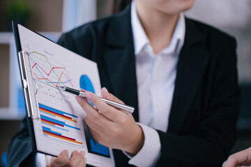 Close up of hands are working on paperworks that shows graft and chart of accounting and financial.