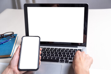 cell phone in the foreground with white background, laptop behind, sales and communications concept