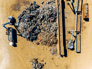 Scrap Metal Recycling. Aerial View of Industrial Scrap Processing. Heavy Machinery Working on Recycling Process.