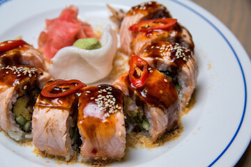 Sushi roll with big shrimp close-up on a white plate