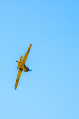 An AT6 Texan goes into roll over the airfield during an airshow.