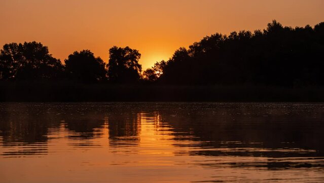 Timelapse of sunrise at calm summer river