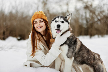 portrait of a woman in the snow playing with a dog outdoors friendship fresh air