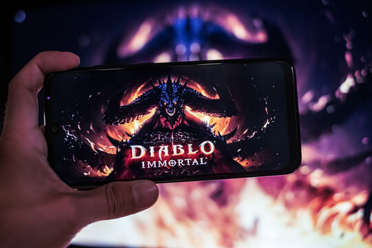 Diablo Immortal Logo, Concept Art And Banner Is Displayed On Smartphone Screen. Mobile Gaming Trend And New Game From Blizzard