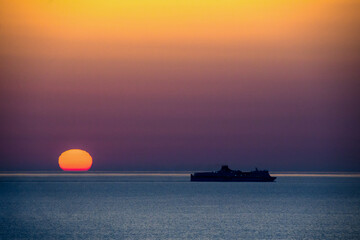 alba con nave 01 - sorge il sole sul mare mentre passa una nave da crociera.