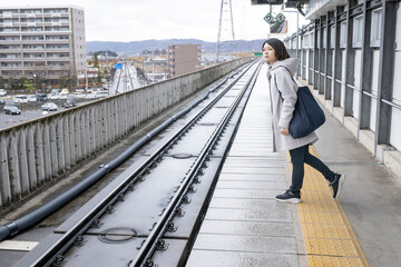 雨に日に駅の中を歩く女性