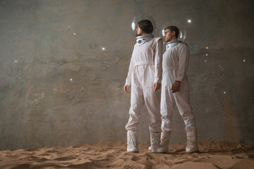 a man and a woman in white futuristic spacesuits explore the planet, astronauts in an empty colony...
