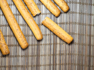 Sesame biscuits and bread on the table. Biscuits are elongated in the form of sticks. Bread products.