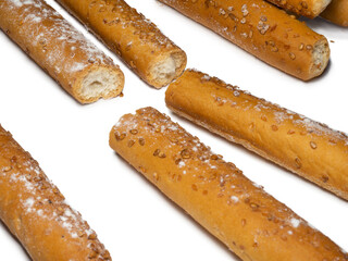 Sesame biscuits on a white background. Biscuits are elongated in the form of sticks. Bread products. Flour products. Lots of homemade cakes. Healthy food.