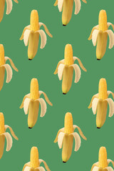 Pattern cob of corn in the peel of banana on green background. Food creative concept. Photo...